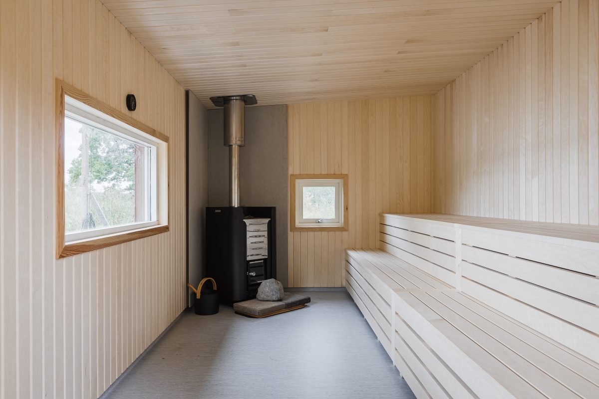 Bastun inifrån med vedeldad kamin, bastusten och ljusa lavar