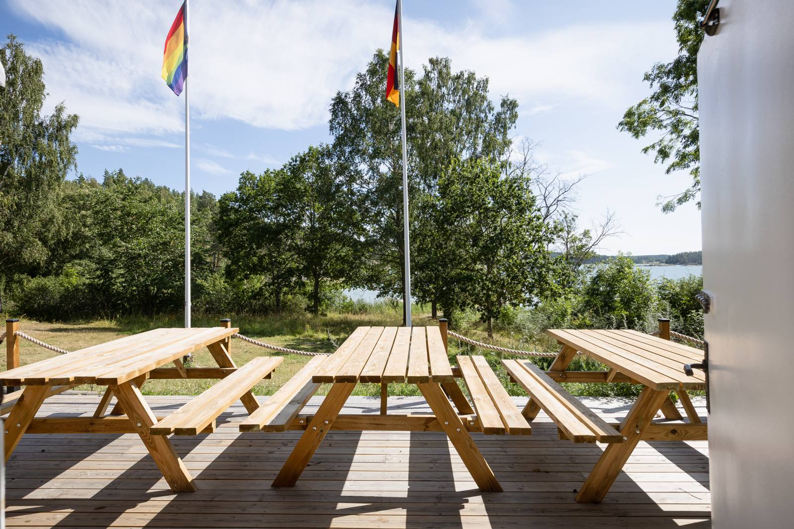 Strandkökets altan med picknickbord och utsikt mot vattnet